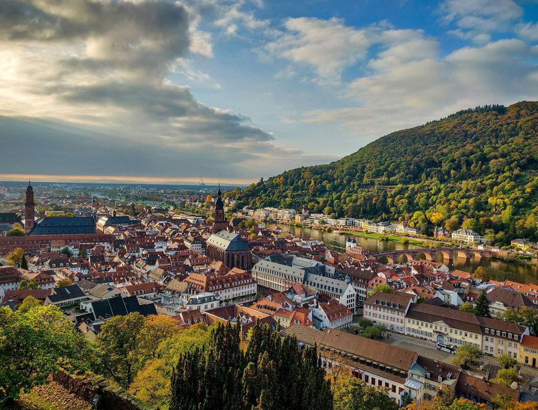 Old town by a river with forested hills